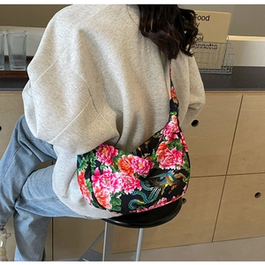 Detail of Chinese floral pattern shoulder bag shown on model in a cozy home setting