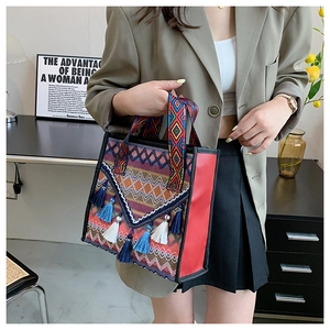 Detail of bohemian tote bag featuring colorful tassels and ethnic woven patterns