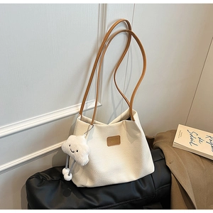 Dettaglio della borsa tote in velluto a coste bianco crema con ciondolo a nuvola