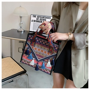 Detail of bohemian woven handbag featuring colorful geometric patterns and long tassels