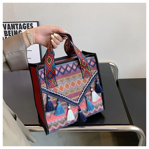 Detailed close-up of ethnic woven tote bag with colorful geometric patterns and tassels