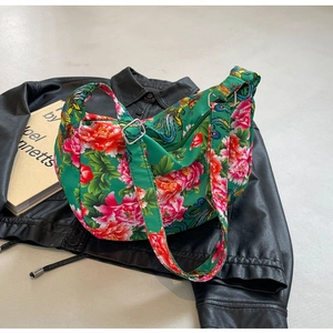 Detail of the green ethnic floral bag showing the adjustable strap and metal buckle