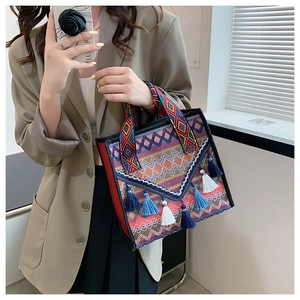Close-up of ethnic tote bag with colorful geometric jacquard patterns and tassel details