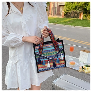 Detail of bohemian tote bag with ethnic patterns and blue white decorative tassels