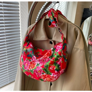 Detail of red floral hobo bag with traditional peony embroidery on shoulder strap