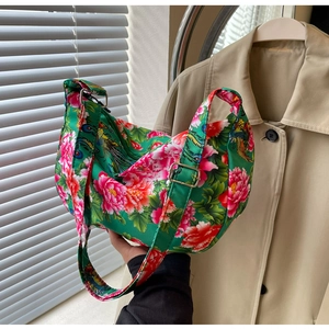 Detail of green floral crossbody bag featuring red peony embroidery and adjustable strap