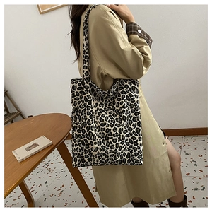 Detail of a large leopard print tote bag styled with a trench coat for a chic urban look