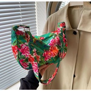 Detail of vibrant green floral crossbody bag with peony patterns and adjustable strap