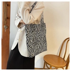 Detail of zebra pattern canvas tote bag styled with casual elegant outfit
