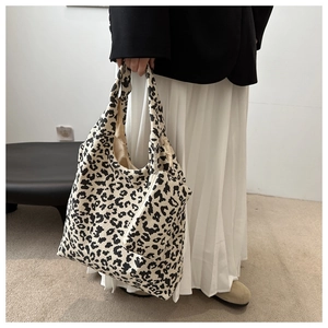 Sac fourre-tout en velours côtelé léopard avec pochette assortie sur une jupe plissée