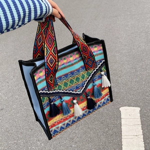Ethnic woven tote bag with colorful geometric patterns and decorative tassels