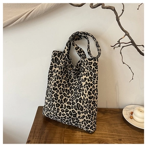 Detail of leopard print tote bag placed on a wooden table with elegant interior decor