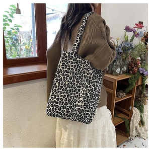 Detailed back view of a large leopard print canvas tote bag styled with a vintage outfit