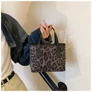 Dettaglio della piccola borsa a secchiello leopardata in ecopelliccia con manico in pelle nera