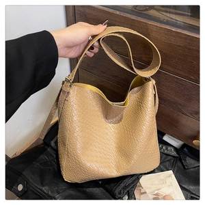 Detail view of light brown tote bag featuring sophisticated crocodile skin texture