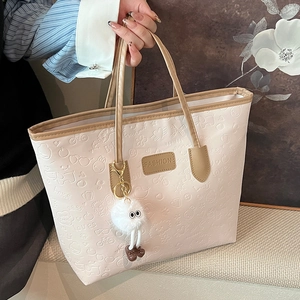 Cream tote bag with cartoon embossing, brown fashion plaque and plush doll pendant