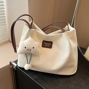 Grande borsa tote crema con trama a nido d'ape, manici in pelle marrone e ciondolo