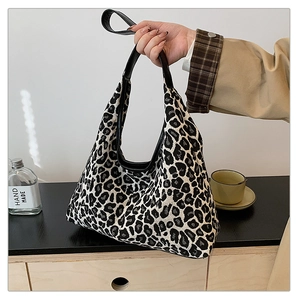 Detail of trendy leopard print fabric tote bag with premium black leather handles