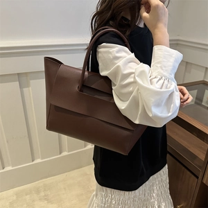 Minimalist large brown leather tote bag for women showing a sleek commuter style