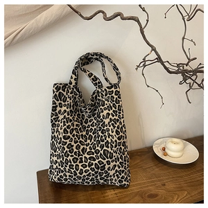 Detail of leopard print canvas tote bag featuring long handles and durable material