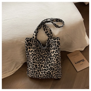 Leopard print canvas tote bag placed on a white bed for a lifestyle aesthetic view