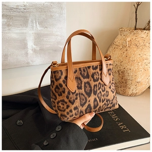 Dettaglio della borsa a secchiello leopardata con finiture dorate e manico in pelle