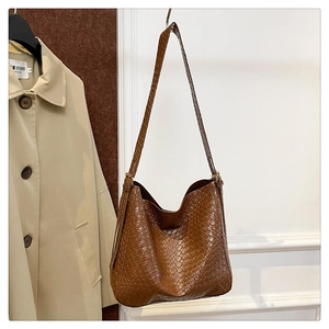 Close-up of caramel brown woven leather texture on large retro hobo shoulder bag