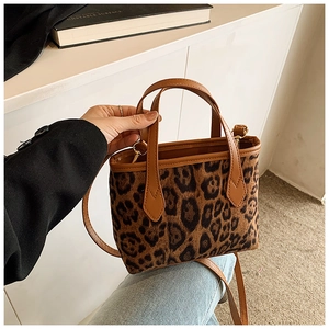 Dettaglio della borsa a secchiello leopardata con manici e tracolla in pelle marrone