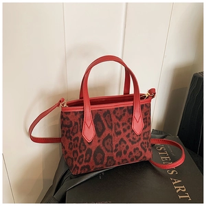 Dettaglio della trama leopardata rossa e delle finiture dorate di questa borsa tote
