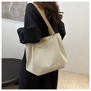 Detailed close-up of a woven tote bag with leather straps and striped texture pattern