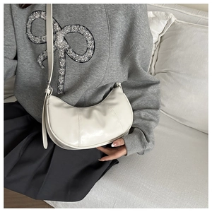 Détail du sac hobo minimaliste en simili cuir beige avec bandoulière et texture fine