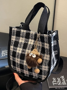 Chic black and white checkerboard canvas handbag with cute brown plush monster charm