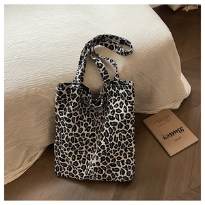 Close-up of a large leopard print canvas tote bag on a minimalist bedroom floor