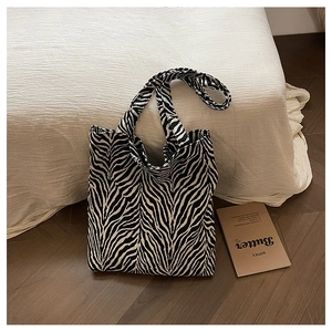 Close-up of zebra print canvas tote bag showing textured fabric and dual handles