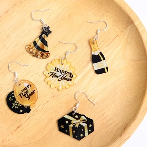 New Year acrylic earrings set in gold and black featuring champagne and party hat motifs