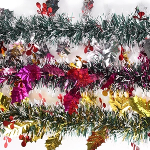 Christmas tinsel garland with metallic green leaves, red berries and white snowy tips