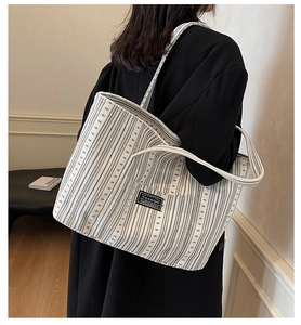 Vue détaillée du grand sac cabas en toile rayée avec étiquette de mode noire devant