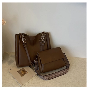 Detail view of deep brown large tote bag and envelope bag set with bohemian strap