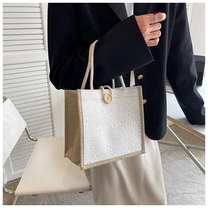 Detail of floral texture canvas tote with cotton rope handles and wooden button closure