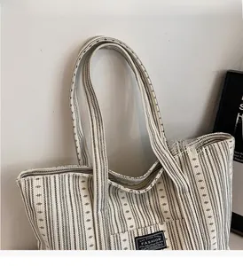 Détail d'un sac cabas tissé noir et blanc avec étiquette tendance et large bandoulière