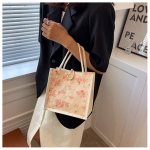 Detail of floral lace lunch bag featuring wood button and woven rope handle design