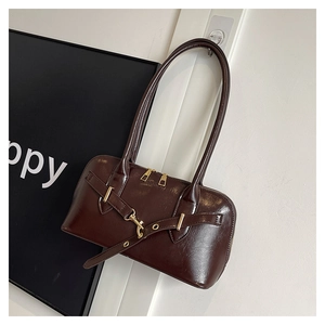 Detail of dark chocolate glossy PU leather shoulder bag with gold zipper and strap