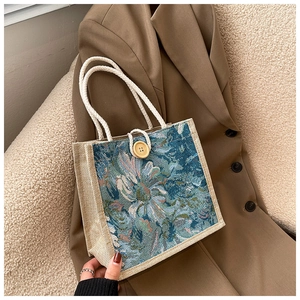 Detail of linen lunch bag featuring oil painting floral patterns and wood button closure