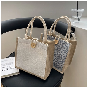 Close-up of linen tote bags with floral patterns, wooden button, and rope handles