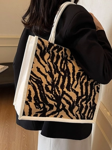 Detail of canvas tote bag with zebra print and white rope handles for daily commute