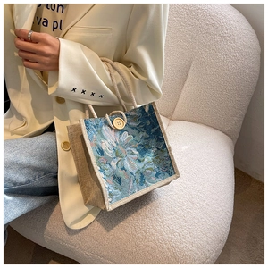 Close-up of floral jacquard fabric and natural jute details on a stylish tote bag