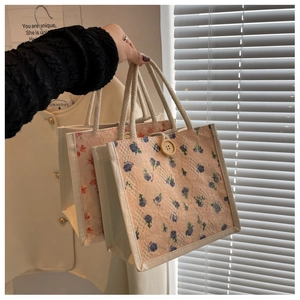 Close-up of floral crochet lace tote bag with vintage wood button and cotton rope handle