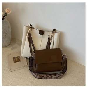 Close-up of beige tote and brown crossbody bag set with herringbone woven shoulder strap