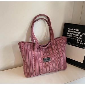 Gros plan du sac cabas en velours côtelé à rayures roses avec étiquette Fashion
