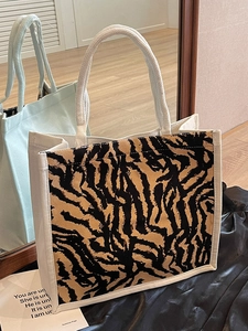 Large canvas tote bag with animal print panel and rope handles in a lifestyle setting
